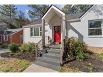 Charming white home with a bright red front door and manicured landscaping and gray steps at 1784 Terry Mill Se Rd, Atlanta, GA 30316