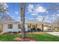Charming single-story home with white brick, a covered porch, and a well-maintained lawn at 5450 Frazer Rd, Buford, GA 30518