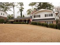 Charming home with manicured landscaping, inviting front porch, and American flag at 1728 Stonecliff Ct, Decatur, GA 30033