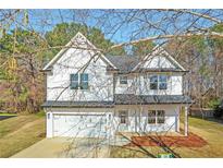 Charming two-story home featuring white siding, an attached garage, and a well-maintained front lawn at 1335 Tumblerock Way, Loganville, GA 30052