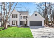 Charming two-story home features a brick facade, well-maintained lawn, and an attached two-car garage at 275 Carriage Chase, Fayetteville, GA 30214