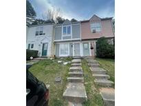 Charming townhomes featuring unique exteriors and inviting front entrances with concrete steps at 404 Prince Of Wales, Stone Mountain, GA 30083