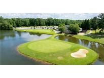 Scenic aerial view of a lush golf course with a pond and clubhouse, perfect for luxury living at 49 Inverness Ct, Hiram, GA 30141