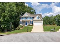 Charming two-story home with blue shutters, white trim and a well-manicured lawn on a sunny day at 49 Inverness Ct, Hiram, GA 30141