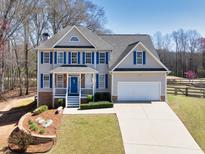Charming two-story home featuring blue shutters, a well-manicured lawn, and a two-car garage at 49 Inverness Ct, Hiram, GA 30141