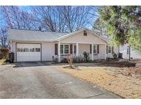 Charming single-story home with a front porch and attached garage, nestled in a quiet neighborhood with mature trees at 1006 Walnut Dr, Lawrenceville, GA 30044