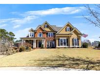 Charming two-story home boasts a well-manicured lawn and inviting curb appeal under a bright blue sky at 112 Bluestone Ct, Acworth, GA 30101