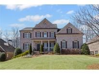 Charming two-story brick home with a manicured lawn and mature landscaping at 3323 Acorn Falls Dr, Marietta, GA 30062