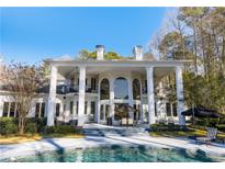 Stunning exterior of home featuring a beautiful pool, patio, and elegant architectural details at 490 Birkdale Dr, Fayetteville, GA 30215