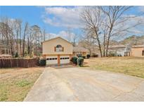 Charming two-story home with a two-car garage and a spacious driveway, ready for new owners at 4161 Windermere Dr, Lithonia, GA 30038