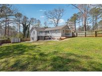 Expansive backyard featuring a well-maintained lawn, white house and wooden fence at 596 Frank Kirk Nw Rd, Kennesaw, GA 30152