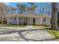 Charming home featuring a covered porch, manicured lawn, and an expansive driveway at 596 Frank Kirk Nw Rd, Kennesaw, GA 30152