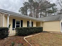 Charming single Gathering home with light yellow siding, dark shutters, and a well manicured yard at , Kennesaw, GA 30152