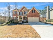 Charming brick home with a well-manicured lawn and inviting two-car garage at 1654 Summersweet Ln, Dacula, GA 30019