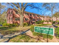 Brick apartment building with landscaped lawn and mature shade trees in a condominium community at 430 Lindbergh Ne Dr # A1, Atlanta, GA 30305