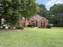 Charming brick home with lush green lawn and mature trees offering great curb appeal at 704 Euel Dr, Mcdonough, GA 30252