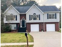 Charming two-story home with a brick and vinyl exterior, complemented by a well-manicured lawn and a two-car garage at 153 Rockport Dr, Mcdonough, GA 30253