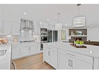 Modern kitchen with white cabinets, stainless steel appliances, and a large island with white countertop at 935 Tiber Cir, Alpharetta, GA 30022