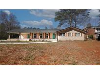 Charming brick home with green doors, wood trim and a spacious front yard at 4585 Yates Rd, Atlanta, GA 30337