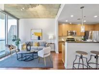 Bright living room featuring wood floors, large window with city views, and an open floor plan to the kitchen at 855 Peachtree Ne St # 3110, Atlanta, GA 30308