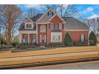 Traditional two-story brick home with a manicured lawn and mature trees, offering classic curb appeal at 4753 Outlook Ne Way, Marietta, GA 30066