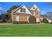 Charming two-story home with stone accents, manicured landscaping, and a lush green lawn at 113 Glenmore Ln, Mcdonough, GA 30253
