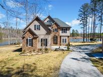 Charming home featuring stone and siding, a driveway, and beautiful lake views at 1401 Rainey Rd, Temple, GA 30179