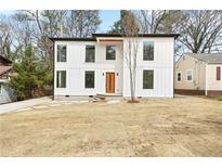 Modern two-story home with white siding, black trim and an orange front door at 1650 Eastport Se Ter, Atlanta, GA 30317