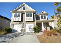 Inviting two-story home with a two-car garage, manicured shrubs, and neutral siding under a clear sky at 2453 Osceola Rd, Lithonia, GA 30058