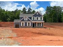 Charming new construction home features a two-story design with a gray exterior, white trim, and an attached garage at 1269 Pj East Rd, Covington, GA 30014