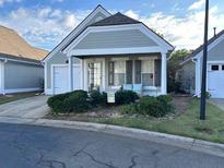 Charming home with lush landscaping and a welcoming front porch at 134 Rose Cottage Ln, Woodstock, GA 30189
