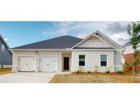 Charming single-story home featuring a two-car garage, brick accents, and a well-maintained front yard at 246 Orwell Dr, Social Circle, GA 30025