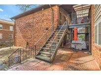 Brick apartment building with a metal staircase leading to upper-level balconies and tiled patio at 1284 Piedmont Ne Ave # 12, Atlanta, GA 30309