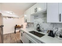 Modern kitchen features white cabinets, white countertops and marble backsplash adding a touch of elegance at 1284 Piedmont Ne Ave # 12, Atlanta, GA 30309