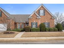 Beautiful brick home featuring manicured landscaping and a symmetrical facade with black shutters at 348 Lauren Ln, Woodstock, GA 30188