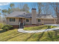 Charming single-Gathering home boasts an inviting front yard and attached two-car garage at 1108 Gwens Sw Trl, Lilburn, GA 30047