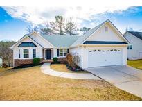 Charming single-story home featuring a two-car garage, well-manicured lawn, and inviting walkway at 419 W Wind W Dr, Villa Rica, GA 30180