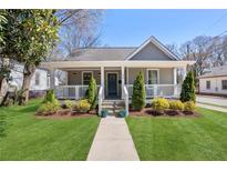 Charming home featuring a inviting front porch, manicured lawn and beautiful landscaping at 938 Allene Sw Ave, Atlanta, GA 30310