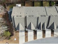 An aerial view of a townhouse complex showcases rooftops and driveway leading up to the garages at 3266 Spicy Cedar Ln, Lithonia, GA 30038