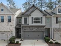 Charming two-story townhome featuring a stone facade and attached two-car garage at 3266 Spicy Cedar Ln, Lithonia, GA 30038