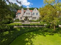 Stunning two-story home features a stone facade, manicured lawn, and lush landscaping at 455 Peachtree Battle Nw Ave, Atlanta, GA 30305