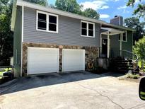 Charming two-story home featuring a gray exterior, stone accents, a two-car garage, and welcoming front entrance stairs at 378 Cole Sw Dr, Lilburn, GA 30047