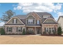 Attractive two-story home with stone and brick accents, professionally landscaped at 504 Taymack Farm Ct, Woodstock, GA 30188