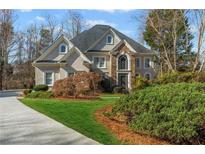 Beautiful two-story home with a combination of stone and stucco exterior, manicured lawn and mature landscaping at 2502 Oak Hill Ovlk, Duluth, GA 30097