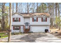 Charming two-story home with red shutters and a two-car garage nestled among trees at 3646 Lenora Church Rd, Snellville, GA 30039