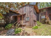 Charming multi-level townhome with rustic wood siding and inviting front porch and wooded surroundings at 4 Quail Run, Decatur, GA 30035