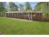 Charming single-story brick home featuring a well-manicured lawn and inviting front porch at 567 Shiloh Nw Rd, Kennesaw, GA 30144