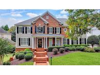 Charming two-story home with a brick facade, a manicured lawn, and professional landscaping at 973 Meadow Club Ct, Suwanee, GA 30024
