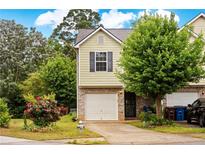 Charming townhome with brick accents, a one-car garage and a well-maintained front yard with lush greenery at 905 Magnolia Gardens Walk, Mcdonough, GA 30253