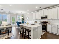 Bright kitchen features an island with seating, stainless steel appliances, and hardwood floors at 355 Cherryhill Ln, Woodstock, GA 30188